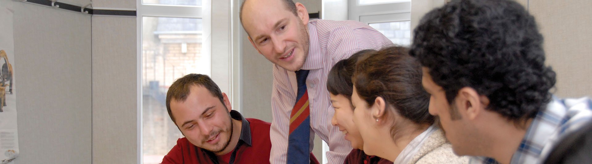 A student talking with a group of students in class