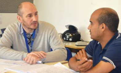 A teacher discusses the class with a student